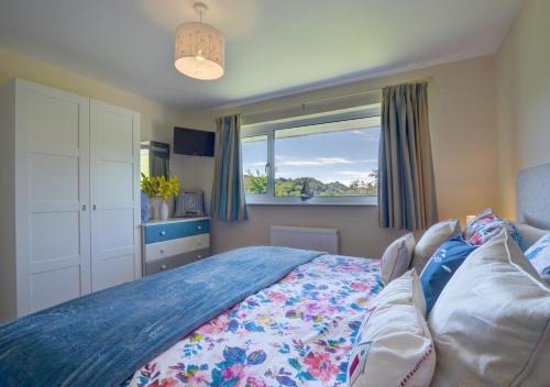 a bedroom with a bed and a window at Bay View Bungalow in Combe Martin