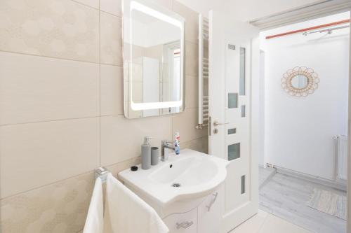 uma casa de banho branca com um lavatório e um espelho em Central House em Sighisoara
