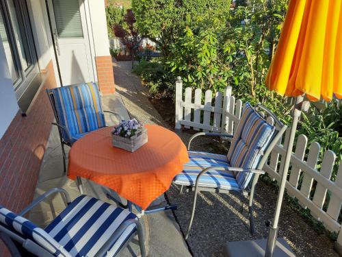 een tafel met stoelen en een parasol op een patio bij Ferienwohnung Haus Sommerberg in Leonhardshof