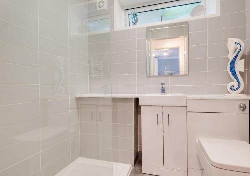 W białej łazience znajduje się umywalka i lustro. w obiekcie Jacka Shack w mieście Saint Martin