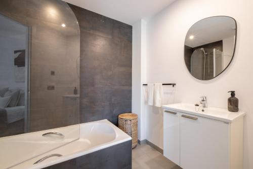 La salle de bains est pourvue d'une baignoire, d'un lavabo et d'un miroir. dans l'établissement La Perla Pollensa - BY EMERALD STAY, à Port de Pollença