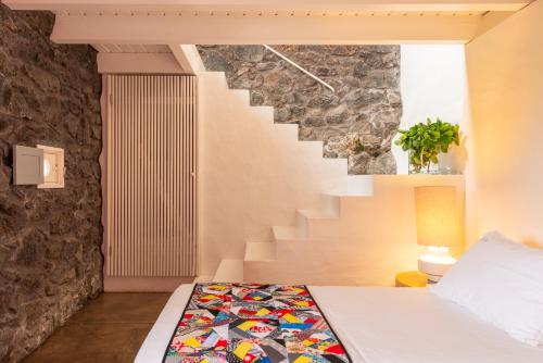 a bedroom with a bed and a staircase at Casas de Incensos - TER -TA in Pontas Negras