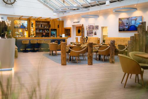 ein Restaurant mit Tischen und Stühlen und eine Bar in der Unterkunft Hotel Am Alten Strom in Warnemünde