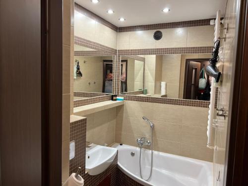 a bathroom with a tub and a sink and a mirror at Last Pub Rynek-Klima-ParkigFree-Netflix-YouTube in Wrocław