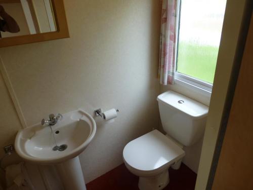 a bathroom with a white toilet and a sink at 73 Port Haverigg in Millom
