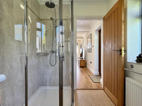 a bathroom with a shower and a bath tub at Beacon Cottage by Inspire Stays in Ditchling