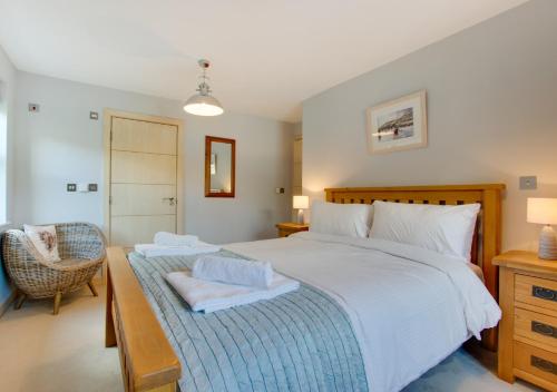 a bedroom with a large bed with two towels on it at Number Six The Creekside in Looe