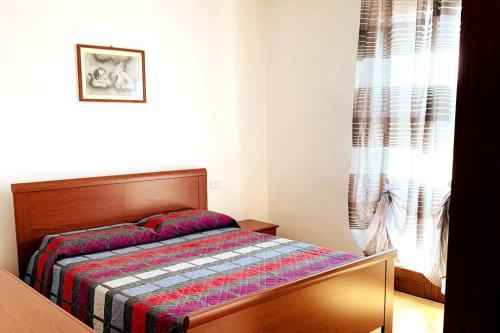 Un dormitorio con una cama con una manta de colores. en La casa di Lory, en Cessalto