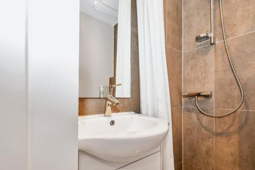 y baño con lavabo blanco y ducha. en Plads til 4 personer - 5 minutter fra Friluftsbadet, en Aalborg