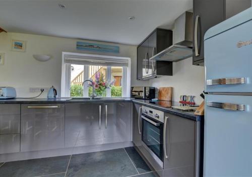 a kitchen with stainless steel appliances and a window at Beren in Croyde