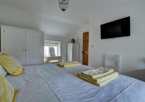 a bedroom with a white bed with towels on it at Beren in Croyde