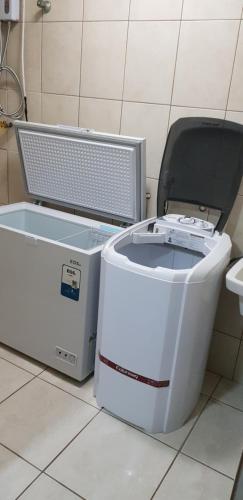 a washing machine and a cooler sitting on a floor at Triplex de veraneio em Guaratuba in Guaratuba