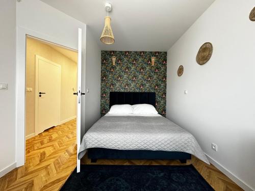 um pequeno quarto com uma cama e uma porta em Apartament Marina em Pierwoszyno