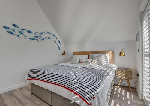 a bedroom with a bed with a blue and white comforter at Beach House in Northam