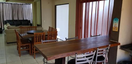 a living room with a wooden table and chairs at Triplex de veraneio em Guaratuba in Guaratuba