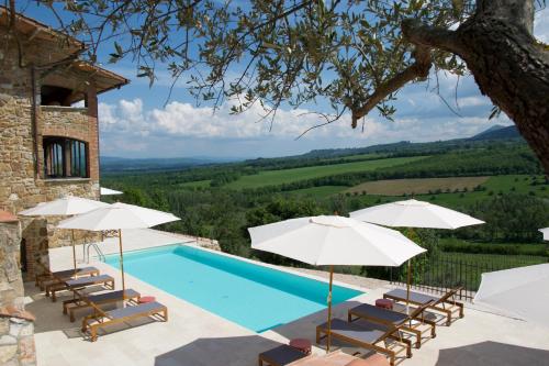 a villa with a swimming pool and umbrellas at Casa M Vineyard in Chianciano Terme