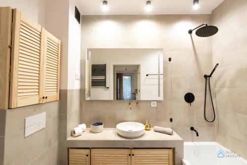 y baño con lavabo, espejo y ducha. en Granero Deluxe by 3City Rentals, en Gdansk