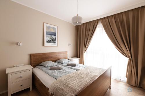 1 dormitorio con cama y ventana grande en Granero Deluxe by 3City Rentals, en Gdansk