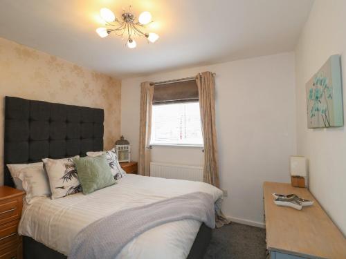 a bedroom with a large bed and a window at Lavender Lodge in Coalville