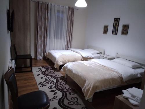 una habitación de hotel con 2 camas y una silla en Hotel Roberto, en Korçë