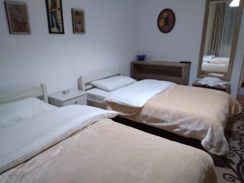 a bedroom with two beds with white sheets at Hotel Roberto in Korçë