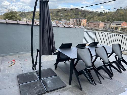 a table and chairs with an umbrella on a patio at Le Franchet in Dinant
