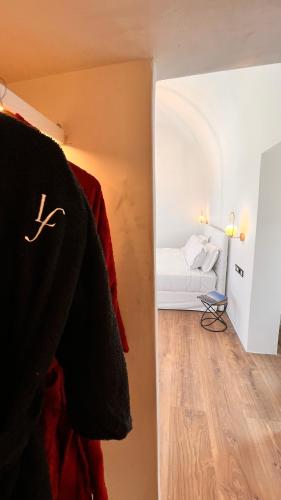 a bedroom with a bed and a room with a hallway at LF Suites & Villas in Imerovigli