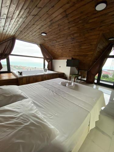 a large white bed in a room with a large window at VİLLA DENİZ , KiRAZ in Trabzon
