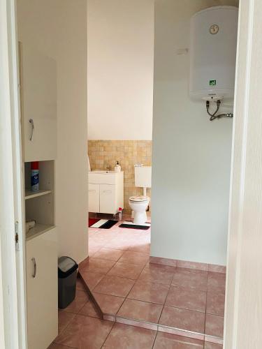 Łazienka z toaletą i podłogą wyłożoną kafelkami w obiekcie R-Andi fészek w Budapeszcie