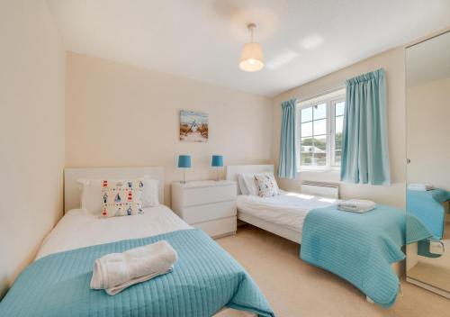 a bedroom with two beds and a window at Brock Cottage in Instow