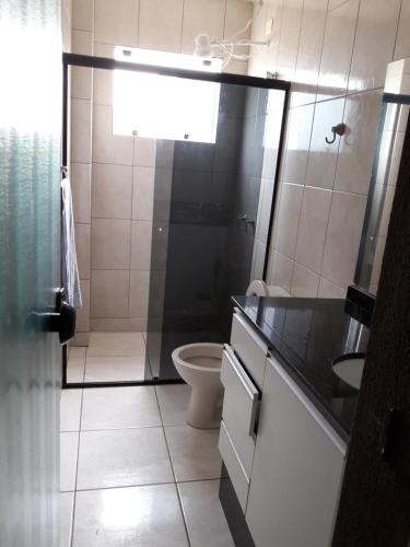 a small bathroom with a toilet and a sink at Triplex de veraneio em Guaratuba in Guaratuba