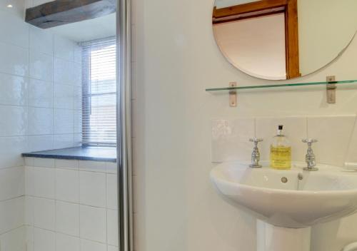 a bathroom with a sink and a mirror and a shower at Bramble Cottage in Barbrook