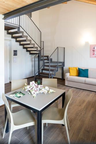 a dining room with a table and chairs and a staircase at CASCINA SANT'ANTONIO in Alba