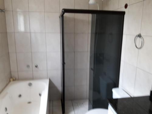 a bathroom with a shower and a tub and a toilet at Triplex de veraneio em Guaratuba in Guaratuba