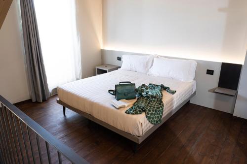 a bedroom with a bed with a bag on it at CASCINA SANT'ANTONIO in Alba