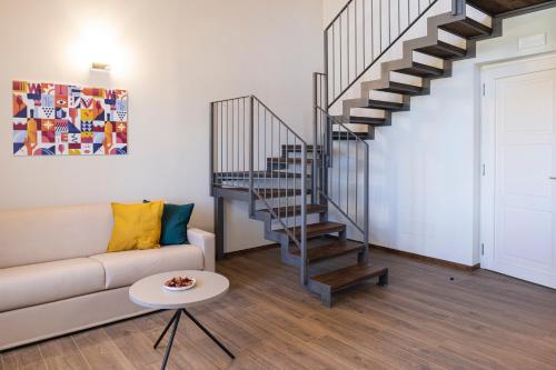 a living room with a couch and a spiral staircase at CASCINA SANT'ANTONIO in Alba