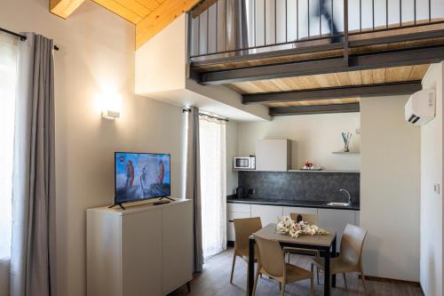 CASCINA SANT'ANTONIO في ألبا: مطبخ وغرفة طعام مع طاولة وتلفزيون
