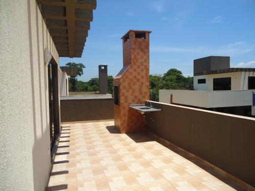 a balcony of a building with a brick tower at Triplex de veraneio em Guaratuba in Guaratuba