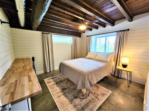 1 dormitorio con 1 cama en una habitación con ventana en Beachside-HotTub-Fireplace-Authentically Northern, en Traverse City