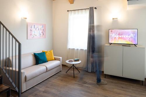 a living room with a couch and a tv at CASCINA SANT'ANTONIO in Alba