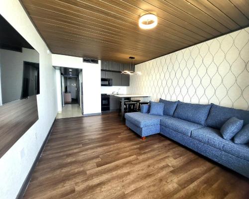 a living room with a blue couch and a kitchen at The Barclay Towers Hotel and Resort in Virginia Beach