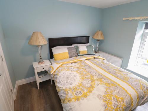 um quarto com uma cama e uma mesa com candeeiros em 22 Town Place em Ballinrobe