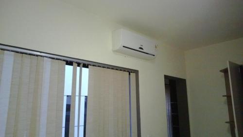 a air conditioner on the ceiling of a room with a window at Triplex de veraneio em Guaratuba in Guaratuba