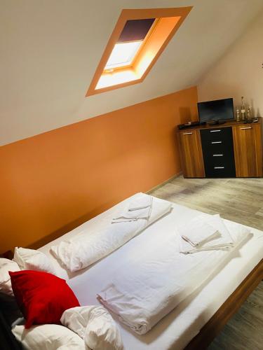 sypialnia z dużym białym łóżkiem i świetlikiem w obiekcie R-Andi fészek w Budapeszcie
