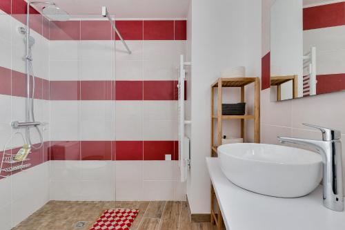 La salle de bains est pourvue d'un lavabo blanc et de carreaux rouges et blancs. dans l'établissement Detente et evasion aux Sables dOlonnes, à Les Sables-dʼOlonne