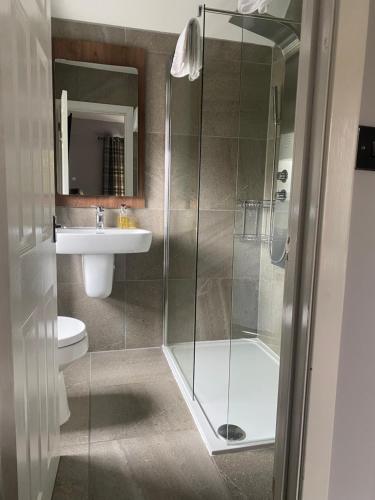 a bathroom with a shower and a toilet and a sink at Garden Rooms in Pitlochry