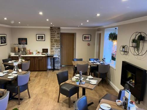 a restaurant with tables and chairs and a fireplace at Garden Rooms, Ferry Rd, Pitlochry in Pitlochry