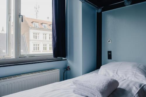 1 dormitorio con cama y ventana en Copenhagen Downtown Hostel, en Copenhague