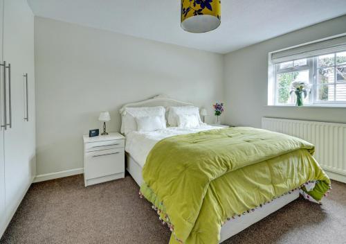 ein Schlafzimmer mit einem Bett mit einer gelben Decke darauf in der Unterkunft Cedars Lodge in Northam