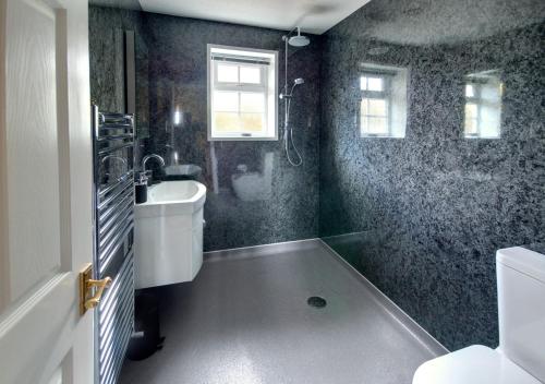 a bathroom with a tub and a sink and a toilet at Cedars Lodge in Northam